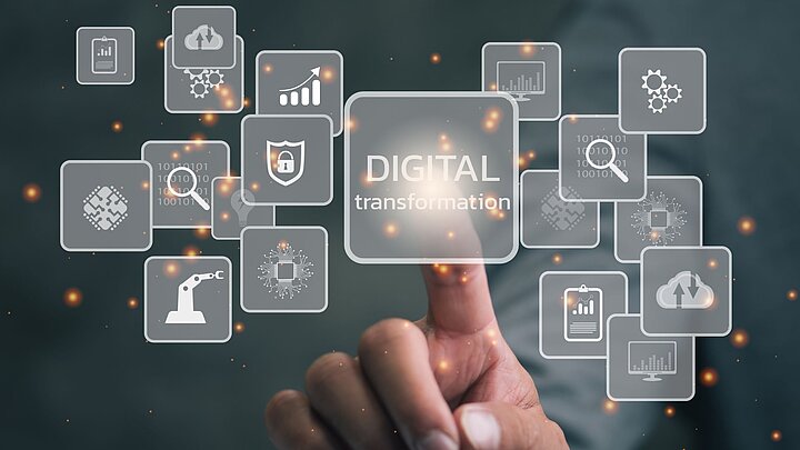 Grafika przedstawiająca palec dotykający wygenerowane cyfrowo pola z ikonami i napisami 