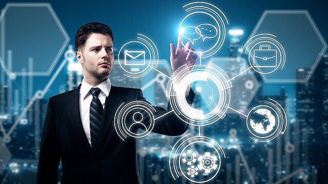 Zdjęcie mężczyzny stojącego przed szklanym ekranem na którym są wygenerowane cyfrowo ikony