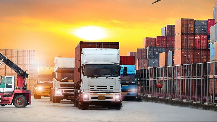 Grafika przedstawiająca ciężarówkę obok kontenerów