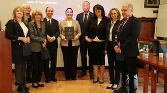 grupa ludzi stojących przed ekranem rzutnika