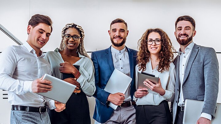 Zdjęcie grupy osób stojących i trzymających w rękach dokumenty