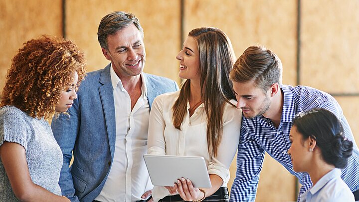 Zdjęcie grupy osób stojących obok siebie i dyskutujących
