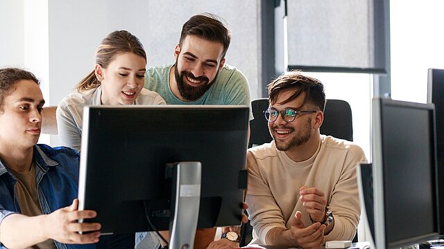 Zdjęcie grupy studentów siedzących przed komputerem