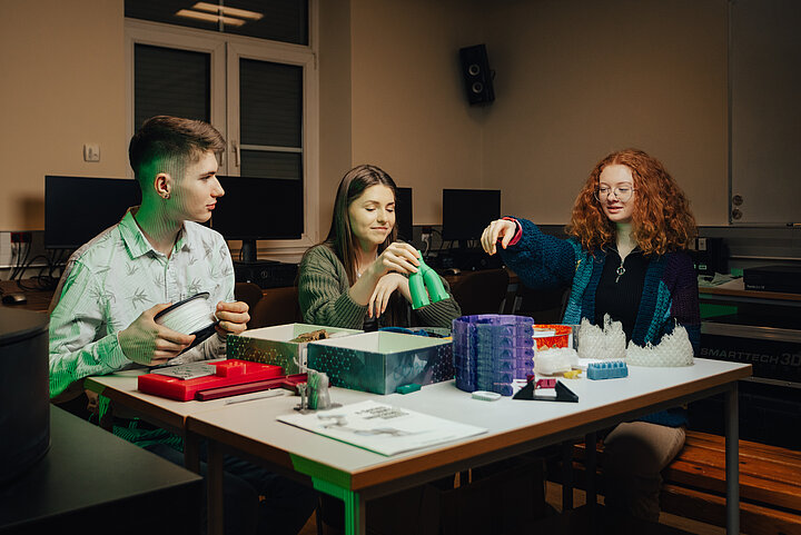 grupa studentów przy stole w sali ćwiczeniowej