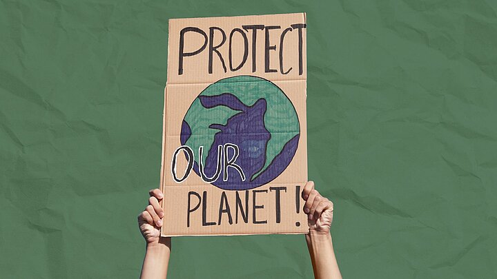 Zdjęcie plakatu z napisem protekt planet trzymanego w rękach z odpadami na zielonym tle