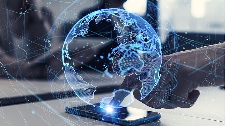 Zdjęcie telefonu dotykanego palcem z wygenerowaną cyfrowo kulą ziemską