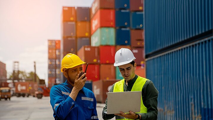 Zdjęcie dwóch osób stojących przy kontenerach