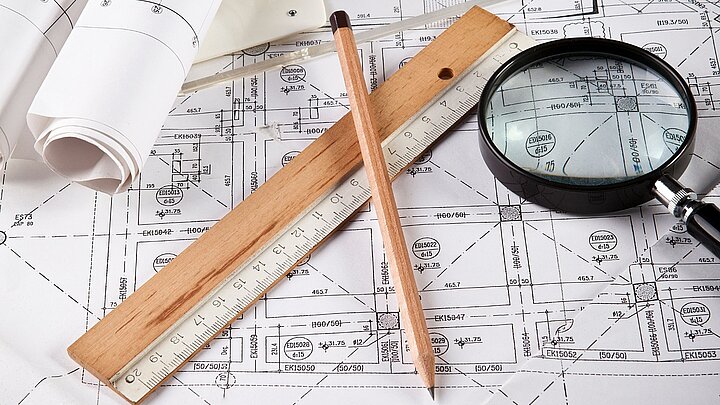 Zdjęcie dokumentacji na której leżą lupa ołówek linijka