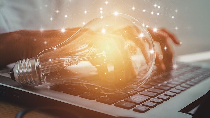 Grafika ze świecącą żarówką na tla laptopa