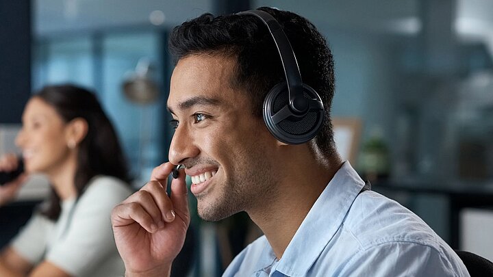 Zdjęcie osoby ze słuchawkami na uszach i mikrofonem przy ustach