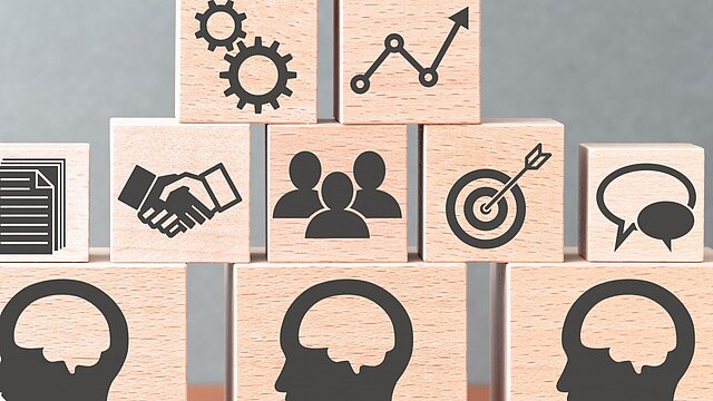 Grafika przedstawiająca ułożone klocki z namalowanymi ikonami