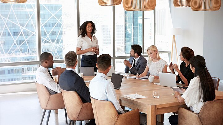 Zdjęcie grupy osób siedzących przy stole i dyskutujących ze sobą