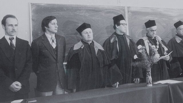 Zdjęcie historyczne przedstawiające grupę stojących osób za stołem