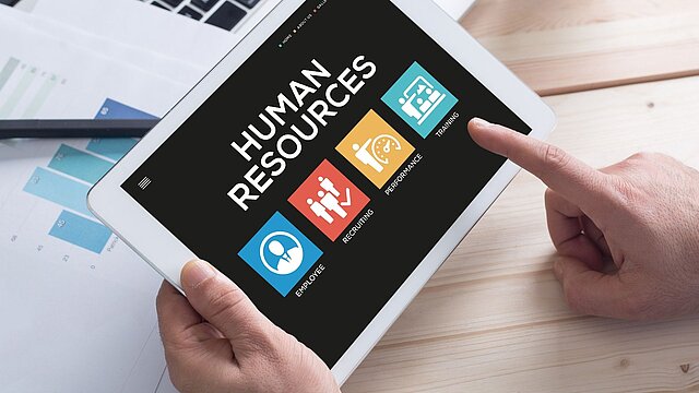 Zdjęcie tableta na którym są wyświetlane napis hjuman resources i 4 ikony