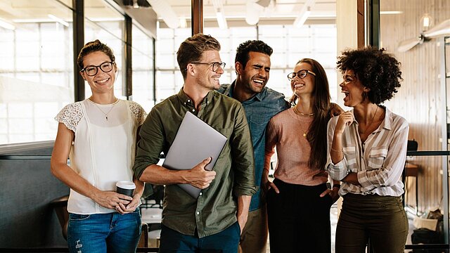 Zdjęcie grupy osób idących po korytarzu biurowca