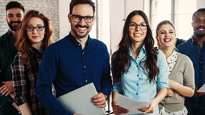 Zdjęcie grupy studentów trzymających w rekach dokumenty