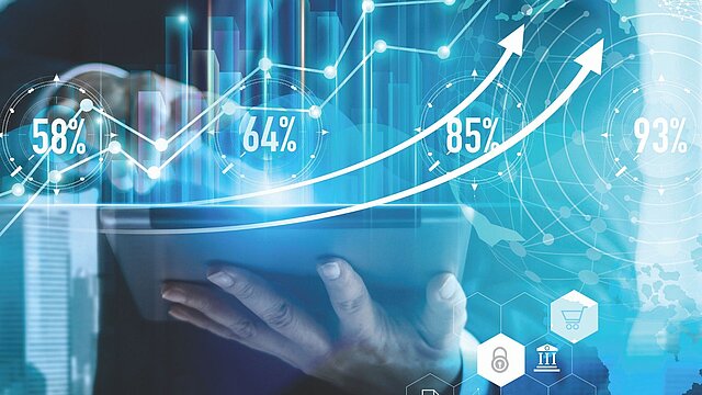 Abstrakcyjna grafika dłoni trzymającej laptor na tle wykresów