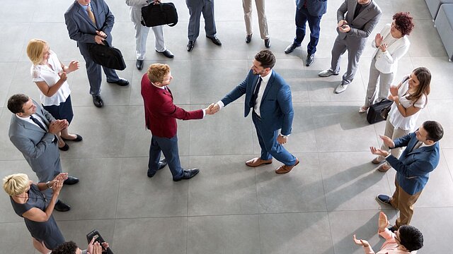 Zdjęcie dwóch osób w kole złożonym z grupy ludzi