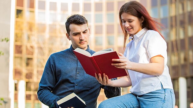 Zdjęcie dwóch osób czytających jedną książkę