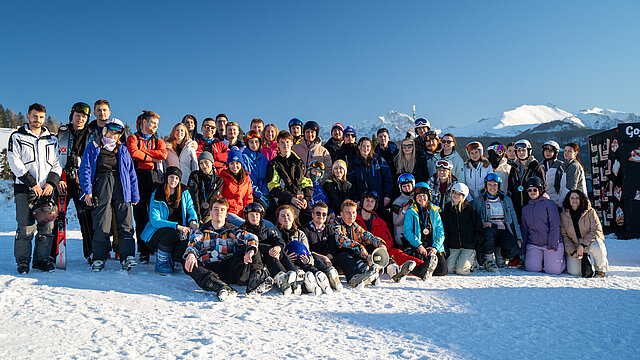 Zdjęcie grupowe studentów stojących na śniegu w strojach narciarskich