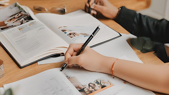 Zdjęcie gazetu z ręką trzymającą długopis