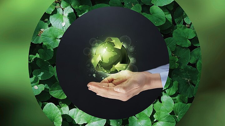 Zdjęcie dłoni podtrzymujących papierową kulę ziemską w kolorze zielonym