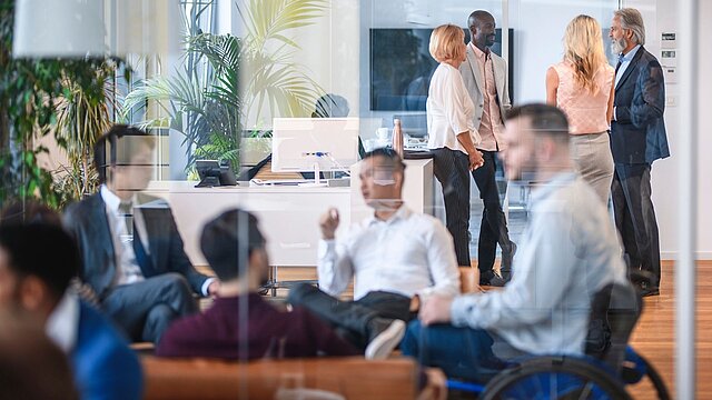 Zdjęcie grupy ludzi rozmawiających w dużym pokoju biurowym